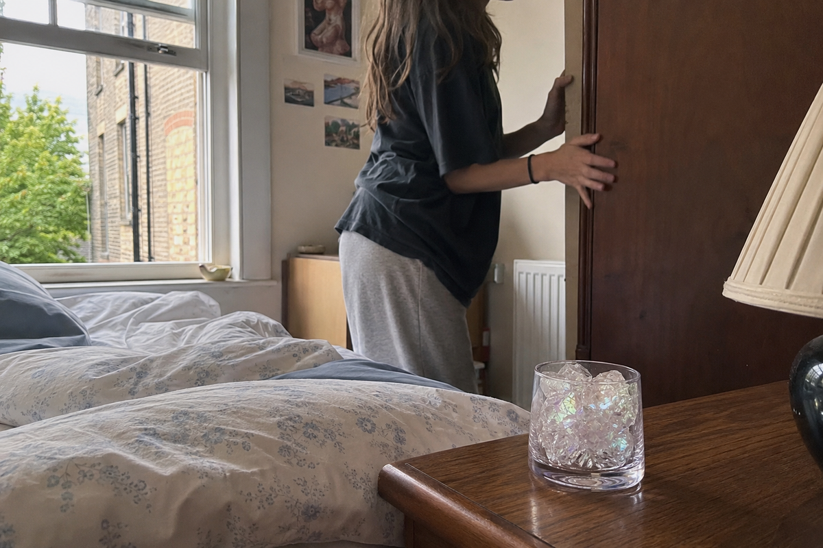 Person checking behind a wardrobe for the source of a musty smell in a flat