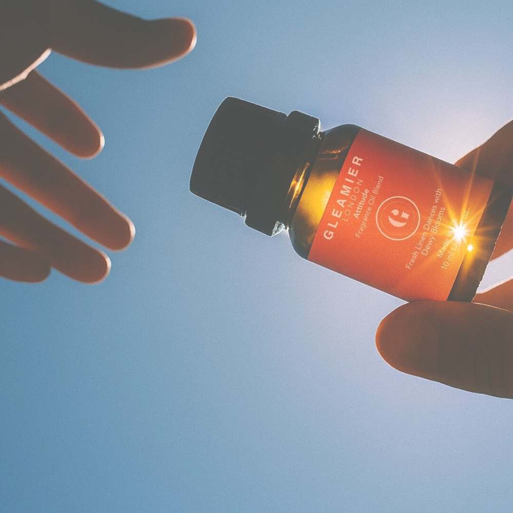 Gleamier Fragrance Oils for Diffusers — bottle held in sunlight — handcrafted diffuser blend for transforming home with scent