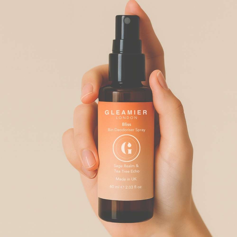 Amber bottle of Bliss Bin Deodoriser Spray in hand, featuring natural antibacterial oils like sage and tea tree for odour-free bins.