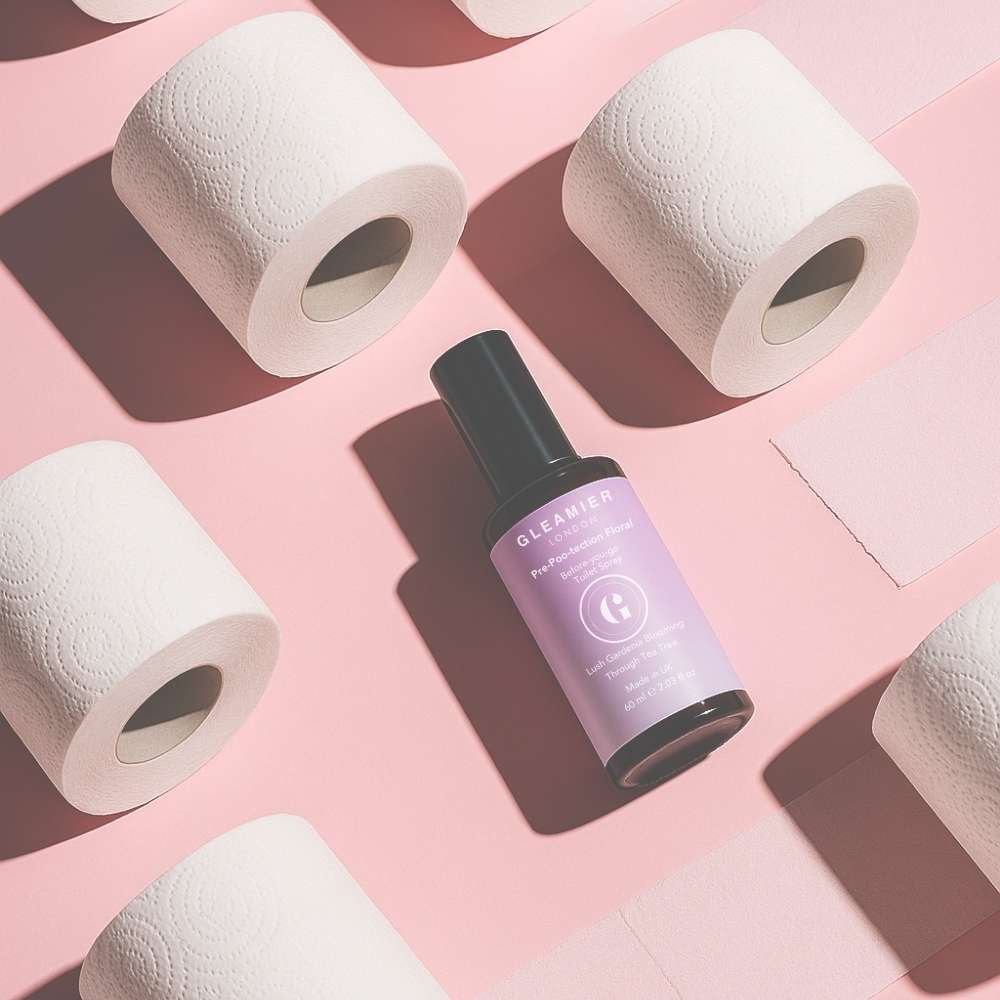 Gleamier pre-poo toilet spray styled with soft white toilet rolls — a gentle alternative to traditional toilet freshener